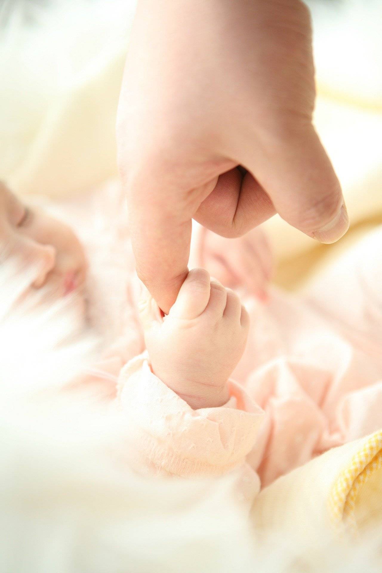 Babys Hand hält den Finger seines Papas